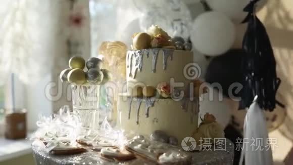 婚礼蛋糕与玫瑰，白色釉和银顶在糖果棒。 生日派对提供蛋糕、饼干和饼干