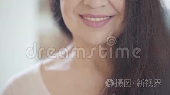 一位年长的女士剪了一张脸的肖像，她带着微笑的嘴唇和华丽的深色长发，笑容满面