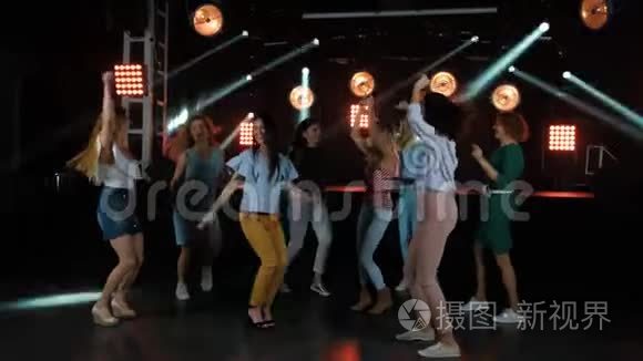 在一家时尚的夜总会的舞池里，快乐的女人随着派对的音乐和其他女朋友跳舞。