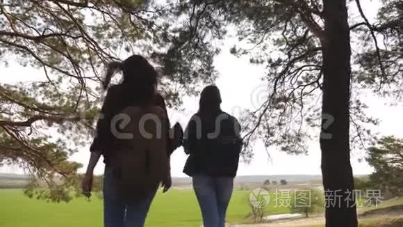 女游客穿过森林。 带背包的性感女性旅行者把手臂伸直，享受自由