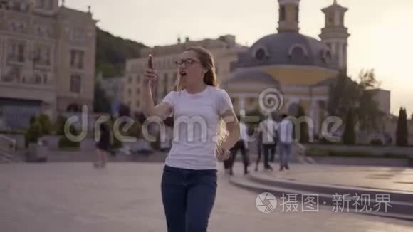 一个幸运的年轻女孩看着电话，在电话里看到了消息好消息。 女人高兴，笑，跳。 4K