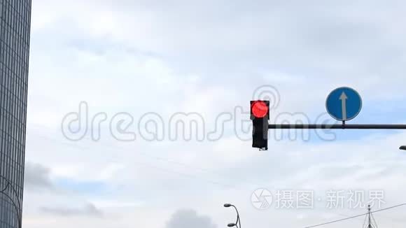 改变交通信号灯和圆形道路方向标志悬挂在柱子上，对抗城市中心的蓝天。 允许