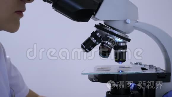 女化验员盯着显微镜的目镜视频