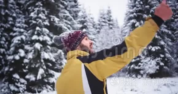 有魅力、长相漂亮的游客在冬天的雪林中用手机自拍，非常