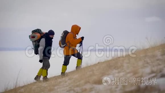 两个人在冬天的斜坡上慢慢地远足