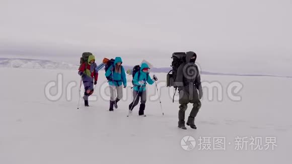 两个男人和女人带着徒步装备和滑雪杆。