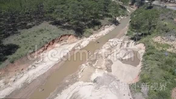 合格的矿工在狭窄的泥泞河流中工作，并提取砂砾