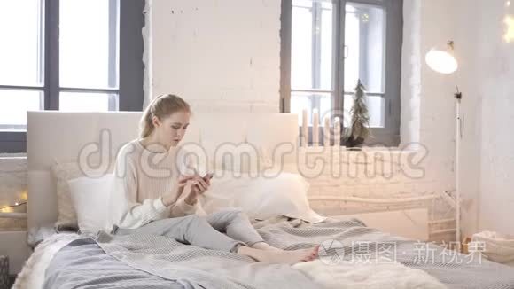 小女孩在床上使用智能手机