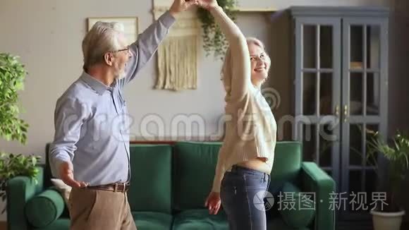 快乐的老情人夫妇在现代客厅跳舞