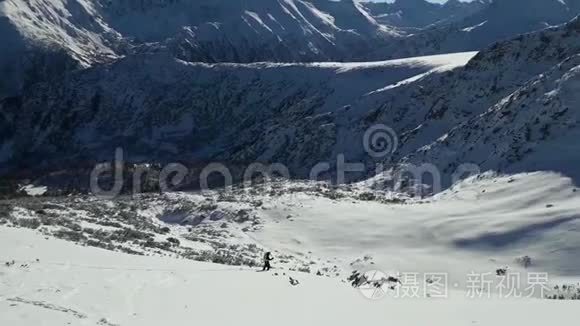 冬天的时候，人们在雪山上滑雪。 晴朗的一天，有蓝天的景观滑雪道。 Pirin山峰，风景如画