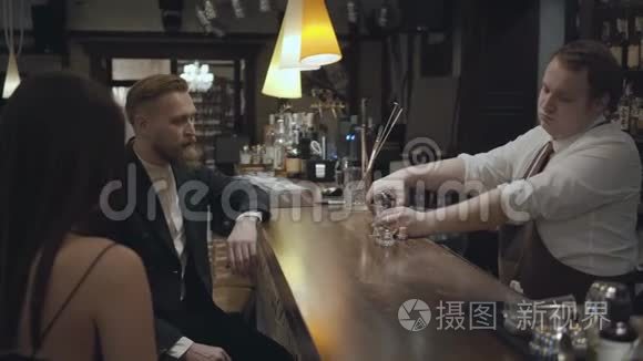 用量杯把酒精倒在杯子里，然后交给顾客。 年轻的胡须男