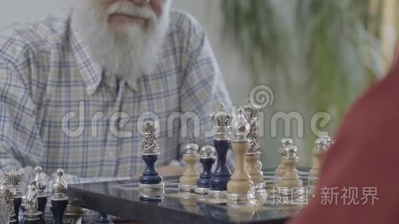 无法辨认的人的手放下了一颗棋子。 两个人在棋盘上握手。 美丽的棋盘