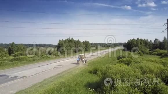 拖拉机在高压线下沿路边割草视频