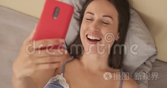 女人一边笑一边用手机聊天视频