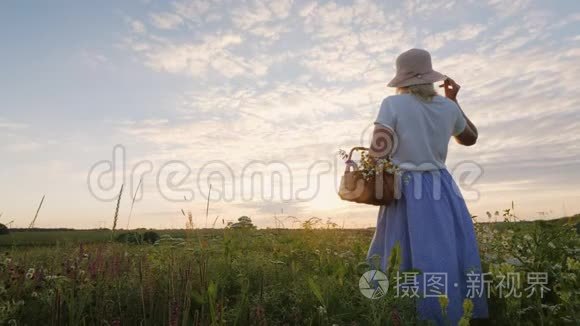 穿着夏装的女人，夕阳下站在草地上的一篮子野花