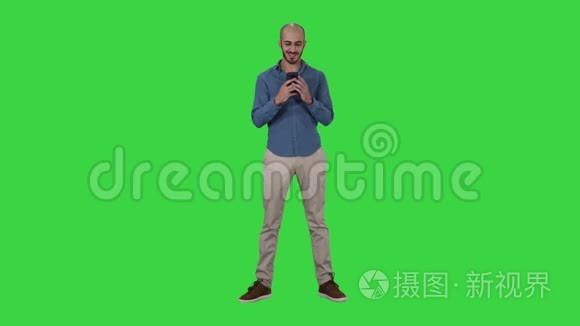 在绿色屏幕上使用手机智能手机书写信息的闲人，Chroma键.