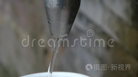 将水从弹簧龙头中注入杯子，在缓慢的运动中关闭