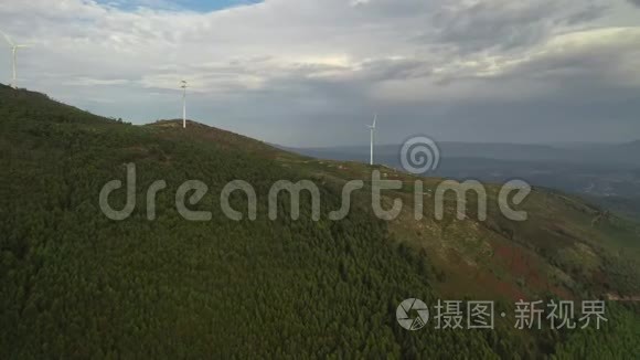 跳伞者靠近山顶的风力涡轮机，飞过绿树