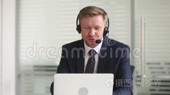 戴耳机说话的商人在手提电脑上打视频电话