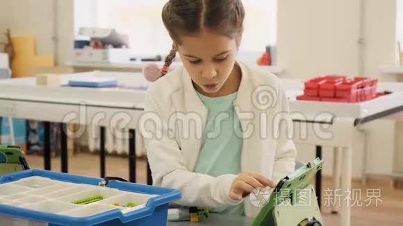 小女孩在她的iPad上展示了“慢动作”教育课的Nessary塑料结构
