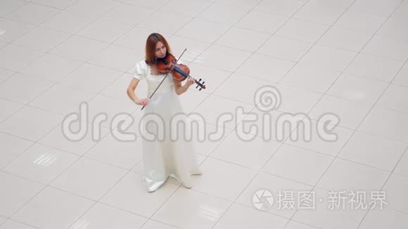 一个穿白色连衣裙的女孩拉小提琴，独自站在房间里。