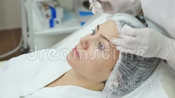 医生在病人脸上用记号笔画出线，用于诊所的面部整形手术