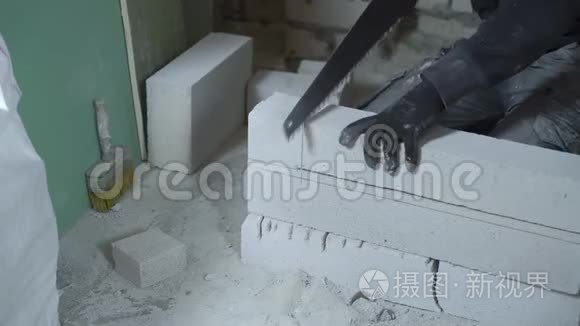 男建筑工人根据标记用手锯锯块的看法