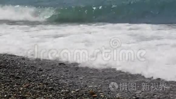 男孩`脚在海里，一个十几岁的少年站在海滩上的鹅卵石海滩上。 自然假期。