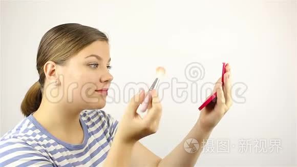 女孩照镜子，擦了擦脸。