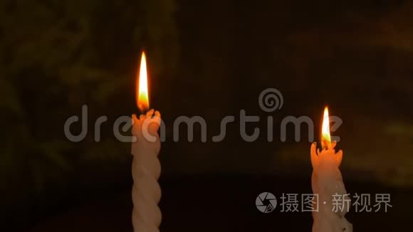 两支燃烧的大蜡烛。 黑暗背景上的亮光。 黑暗模板。 生日派对。 浪漫之夜