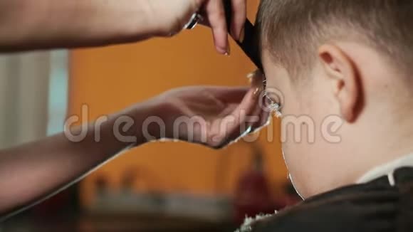 一个女理发师在美发沙龙里给男孩梳头 手特写 有选择的焦点 头发mov格式视频下载 正版视频编号02s900 摄图新视界视频库