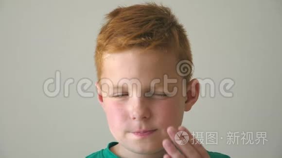 有雀斑的红发男孩的肖像。 绝望的孩子在室内思考他的问题。 关闭情绪