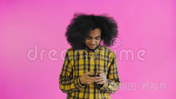 非洲裔美国人的肖像，卷发，在紫色背景下的智能手机上聊天。 情感概念