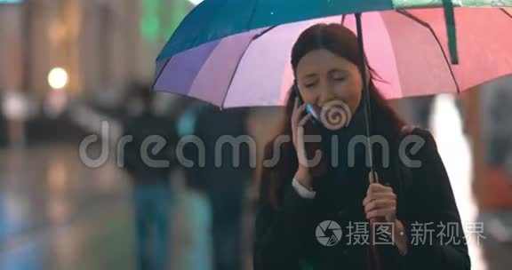 带着雨伞的年轻女子在打电话视频