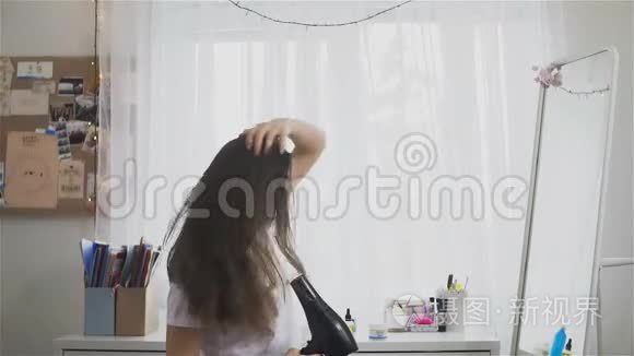 女人在房间里用吹风机吹干头发视频