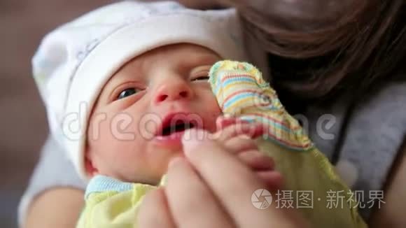 母亲抱着新生手的特写镜头。宝宝抓着妈妈的手指。