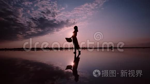 一个女人在夕阳背景下挥舞着裙子的剪影