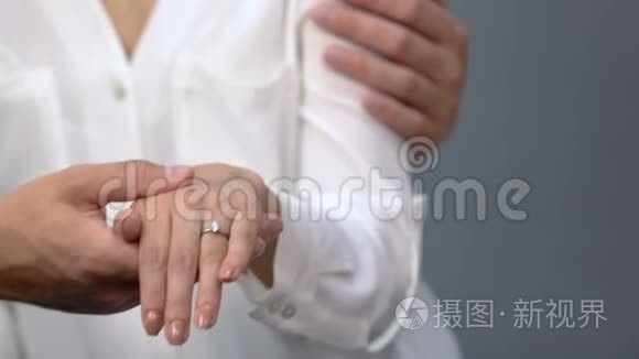 有爱的一对夫妇把订婚戒指戴在女朋友的手指上给母亲看，婚姻