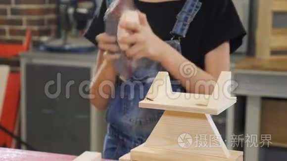 儿童木工制造。 十岁的女孩用磨砂布和木头工作。 小女孩的特写