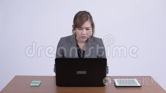 年轻认真的亚洲女商人一边工作一边思考着笔记本电脑