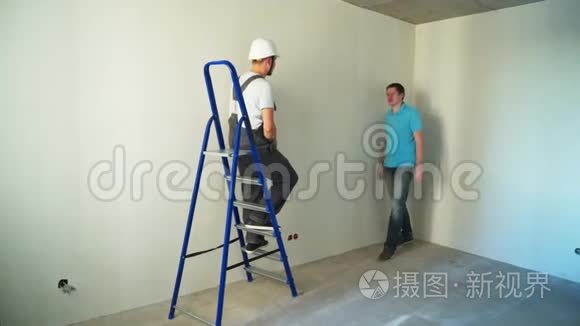 施工现场两名工人在墙上贴墙纸视频