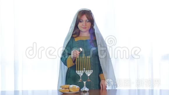 犹太妇女在光明节上用漂亮的烛台点燃蜡烛