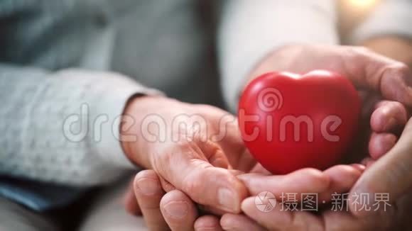 年长夫妇双手呈红色心形