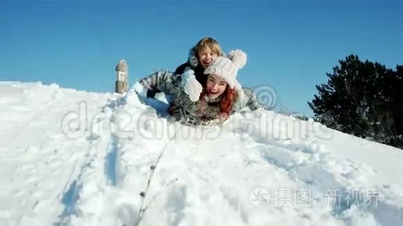 一家人坐雪橇穿过雪地，快乐的母子俩坐着雪橇，滑下山坡，飞快地往下走