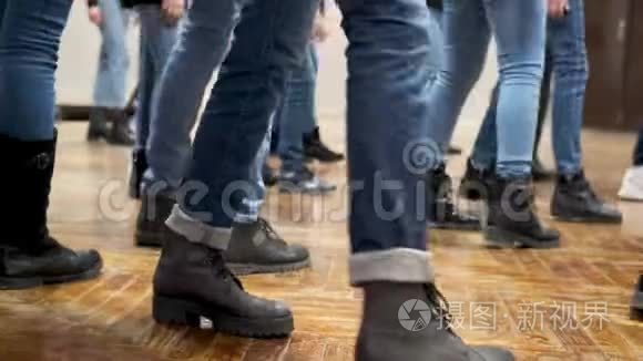 大群儿童同步穿着蓝色牛仔裤和黑色靴子跳舞.. 培训