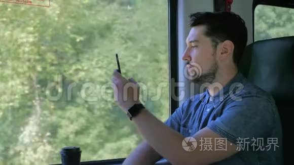 高加索人坐火车旅行。 在移动智能手机上拍摄大自然的照片。 慢动作关闭