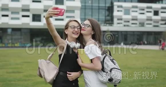 两个年轻女孩在智能手机上自拍自我肖像照片。 女性表现出积极的情绪