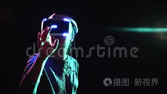在黑暗空间触摸虚拟屏幕的VR耳机女孩
