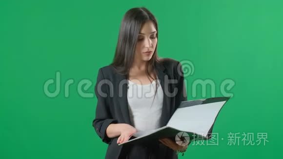 年轻快乐女商人的肖像与黑色文件夹，隔离与绿色屏幕背景。 商业成功