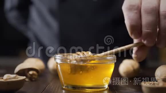 厨师蘸木蜂蜜，用液体蜂蜜粘在玻璃碗上，用蜂蜜烹饪，用天然蜂蜜做甜食